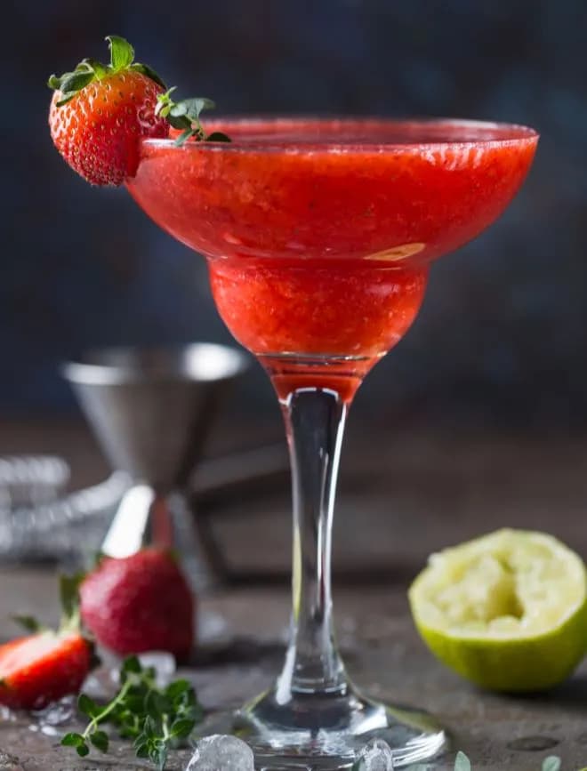 Ice Strawberry alcohol cocktail with lime and rum in a glass