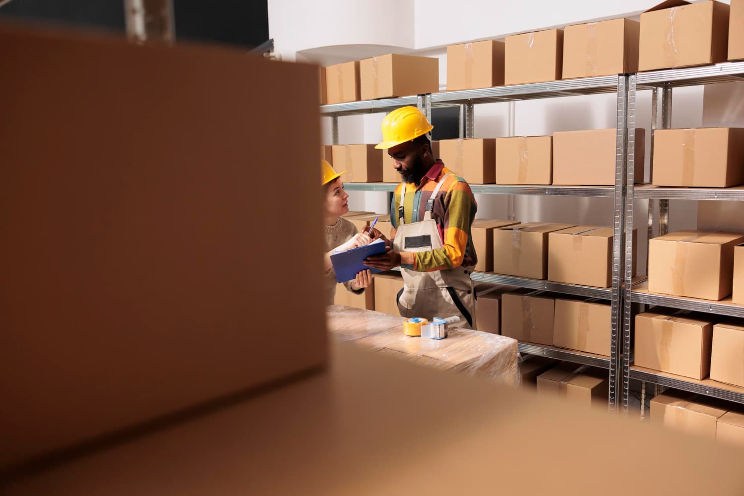 The business owner is inspecting nearly empty warehouse shelves due to an inventory shortage.